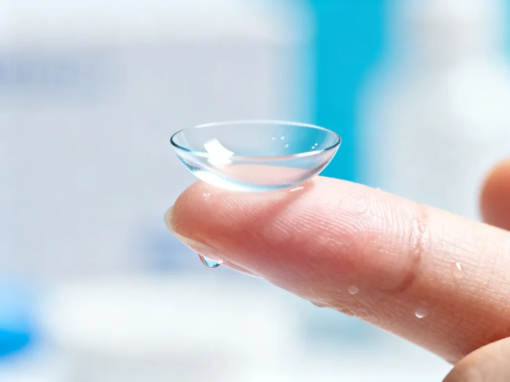 Soczewka kontaktowa Acuvue Oasys na czystym opuszku palca w zbliżeniu, ukazująca precyzyjne wykonanie produktu.