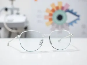 Stylowe okulary Poeurva położone na minimalistycznym drewnianym biurku w słonecznym, nowoczesnym biurze.